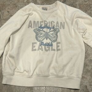 it’s a small white sweatshirt from american eagle that has a butterfly on it